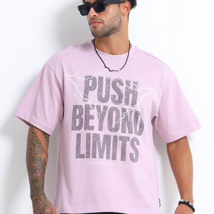 Man wearing a light purple t-shirt with 'Push Beyond Limits' text, sunglasses, and black pants on a white background.