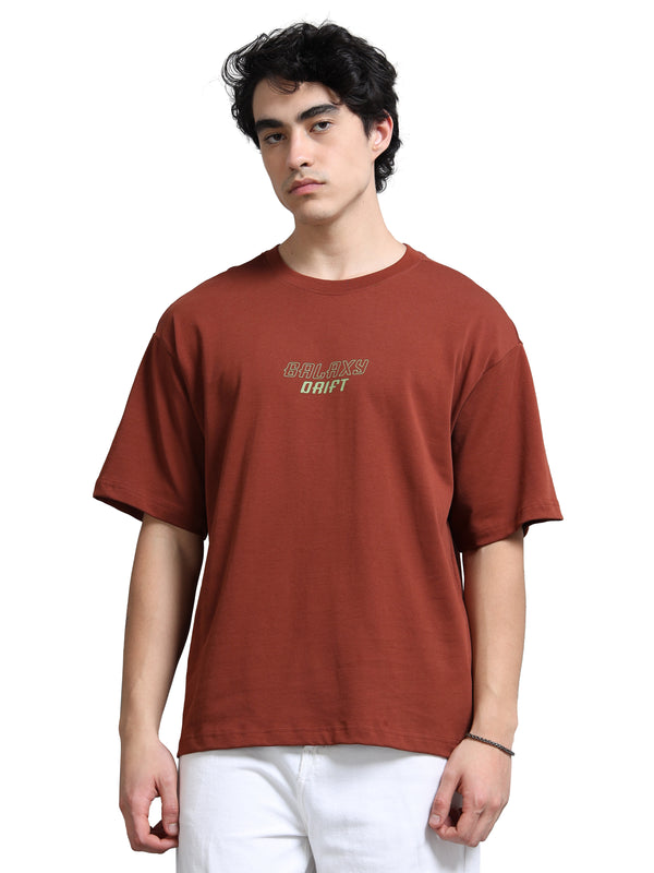 Person wearing a brown t-shirt with text on a white background