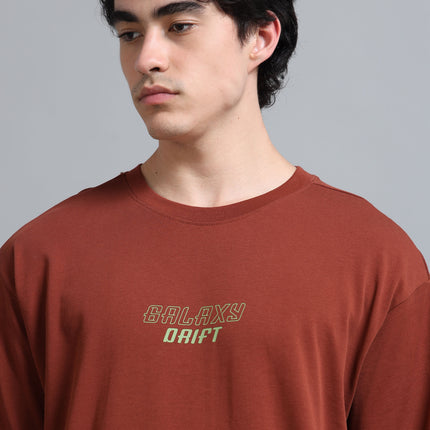 Man wearing a brown t-shirt with 'Galaxy Drift' text on a gray background
