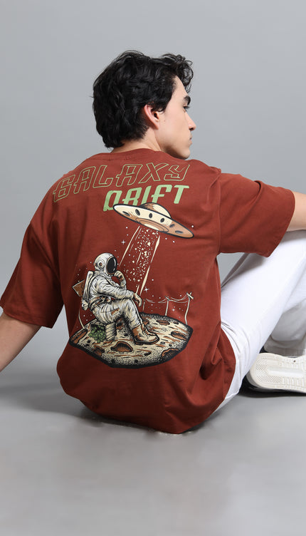 Person wearing a brown t-shirt with space-themed design and text on a gray background
