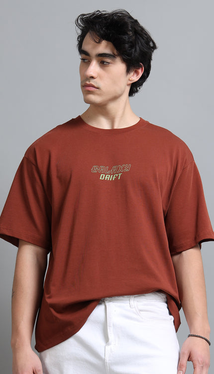 Person wearing a brown t-shirt with text on a gray background